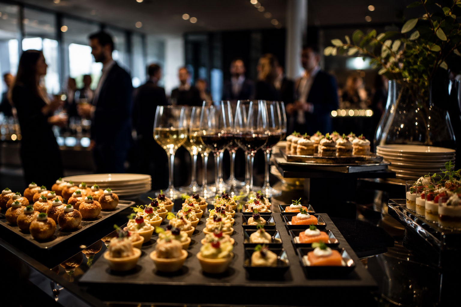An elegant corporate reception with glasses of wine, finger food and guests in the background